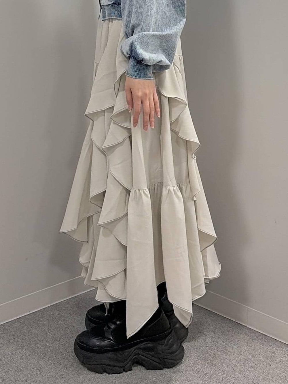 ブラック系のブーツ、ブラック系のニット/セーター、ベージュ系のスカートを着用したレディースの冬コーディネートの6枚目の写真