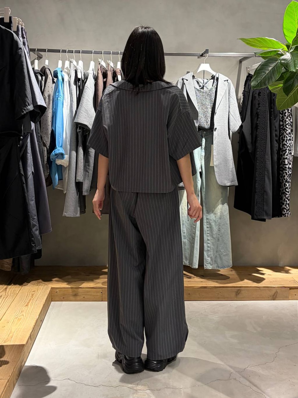 ブラック系のサンダル、ブラック系のTシャツ/カットソー、グレー系のスラックスを着用したレディースの夏コーディネートの3枚目の写真