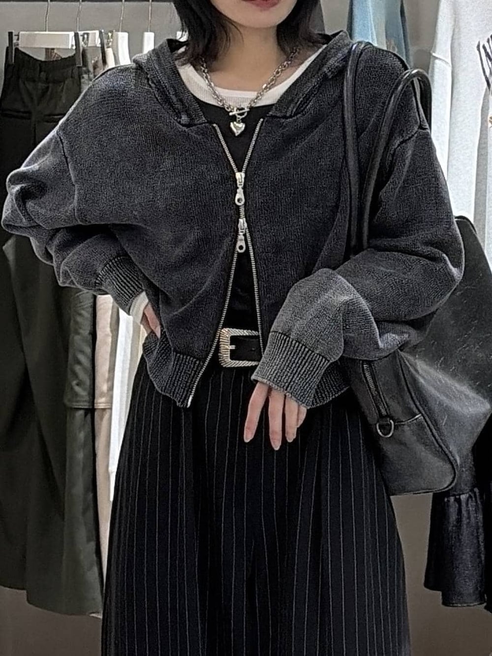 ブラック系のボストンバッグ、ブラック系のスラックス、グレー系のパーカーを着用したレディースの冬コーディネートの4枚目の写真