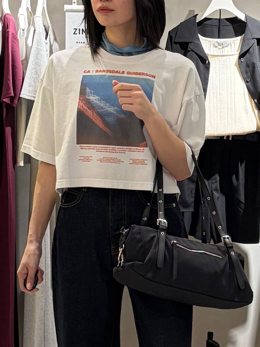 ブルー系のデニムパンツ、ブラック系のサンダル、ブラック系のトートバッグを着用したレディースの春コーディネートの4枚目の写真