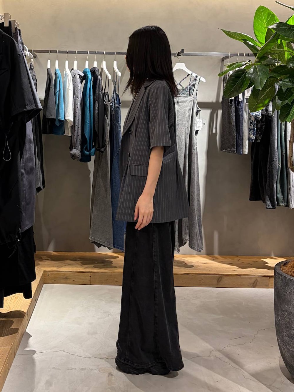 ブラック系のデニムパンツ、ブラック系のTシャツ/カットソー、ブラック系のサンダルを着用したレディースの夏コーディネートの2枚目の写真