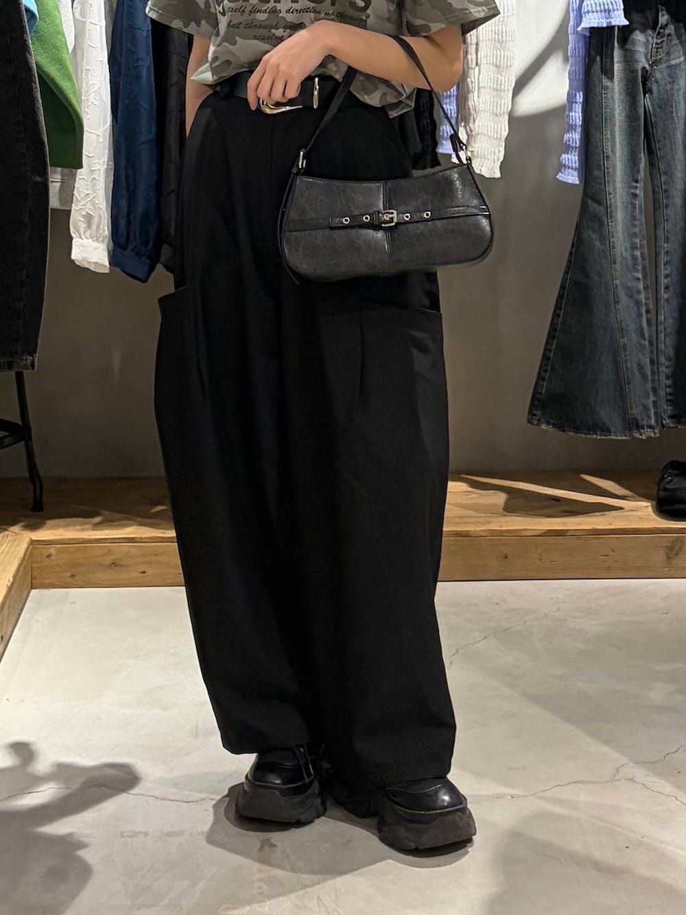 ブラック系のブーツ、ブラック系のハンドバッグ、その他のTシャツ/カットソーを着用したレディースの春コーディネートの5枚目の写真