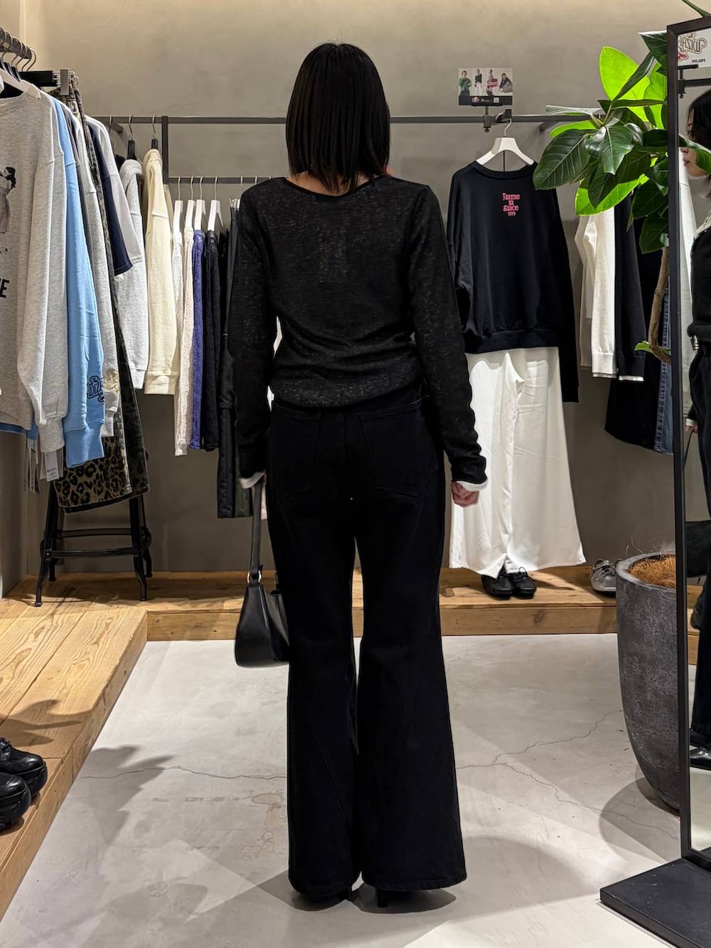 ブラック系のデニムパンツ、ブラック系のハンドバッグ、ブラック系のサンダルを着用したレディースの冬コーディネートの3枚目の写真