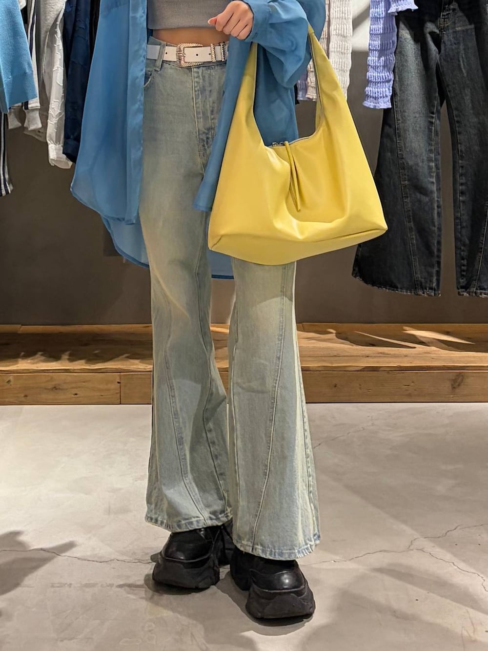 ブラック系のブーツ、グレー系のキャミソール、ブルー系のデニムパンツを着用したレディースの春コーディネートの5枚目の写真