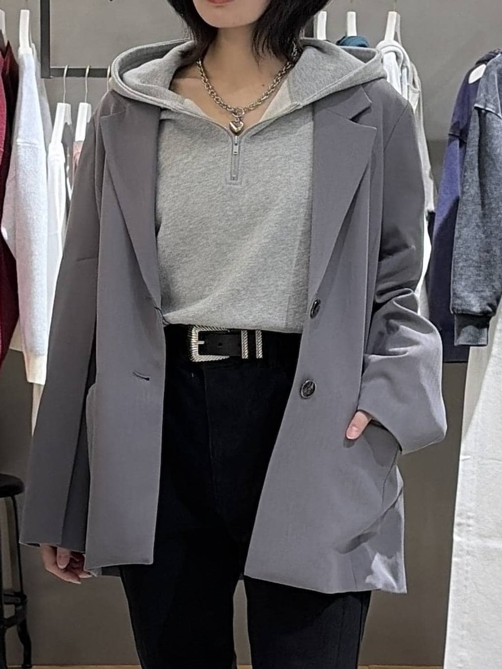 ブラック系のブーツ、ブラック系のデニムパンツ、グレー系のパーカーを着用したレディースの冬コーディネートの4枚目の写真