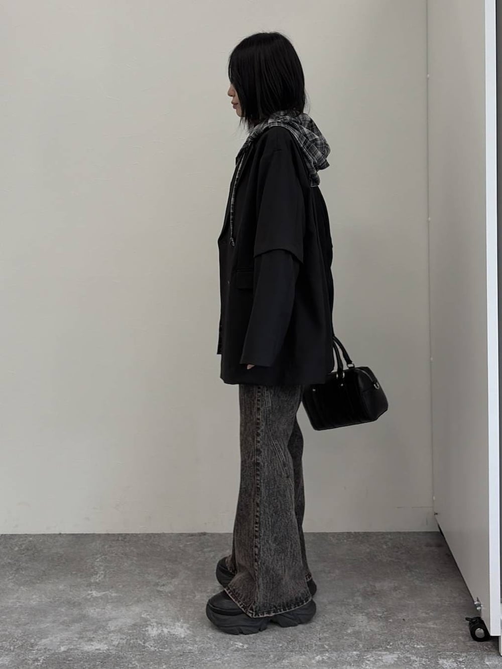 ブラック系のブーツ、ブラック系のボストンバッグ、ブラック系のテーラードジャケットを着用したレディースの春コーディネートの2枚目の写真