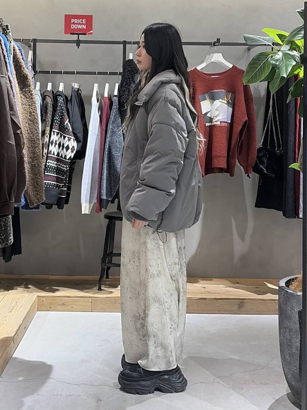 ブラック系のブーツ、グレー系のブルゾン、ホワイト系のスカートを着用したレディースの冬コーディネートの2枚目の写真