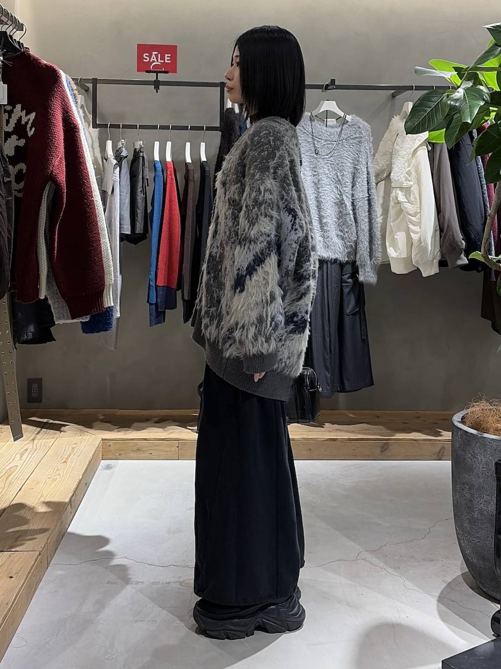 グレー系のカーディガン/ボレロ、ブラック系のニット/セーター、ブラック系のボストンバッグを着用したレディースの冬コーディネートの2枚目の写真