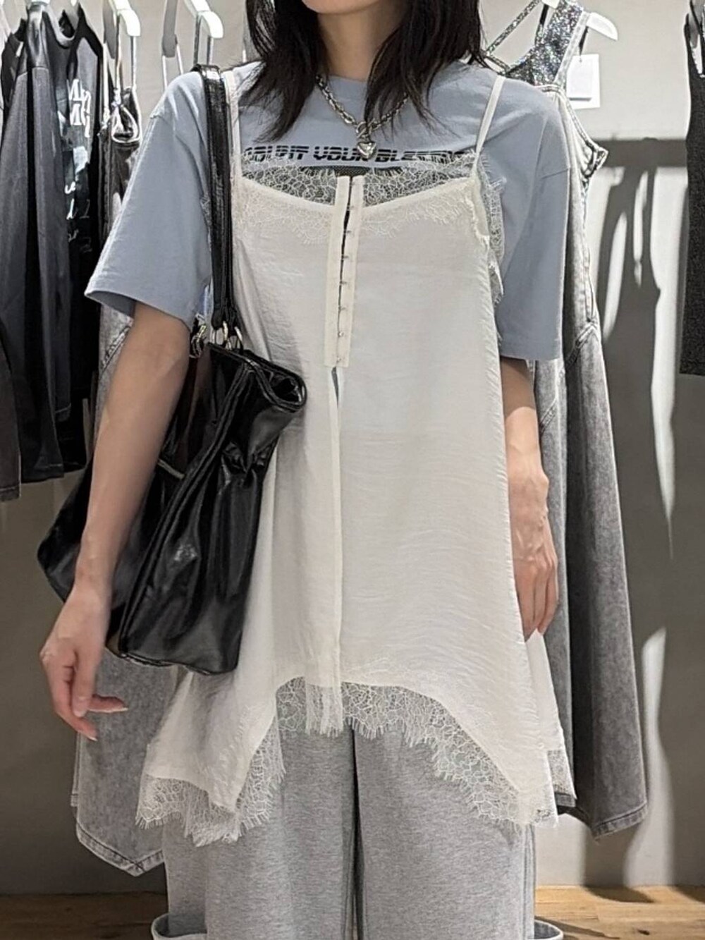 ブルー系のTシャツ/カットソー、ブラック系のサンダル、ホワイト系のキャミソールを着用したレディースの夏コーディネートの4枚目の写真