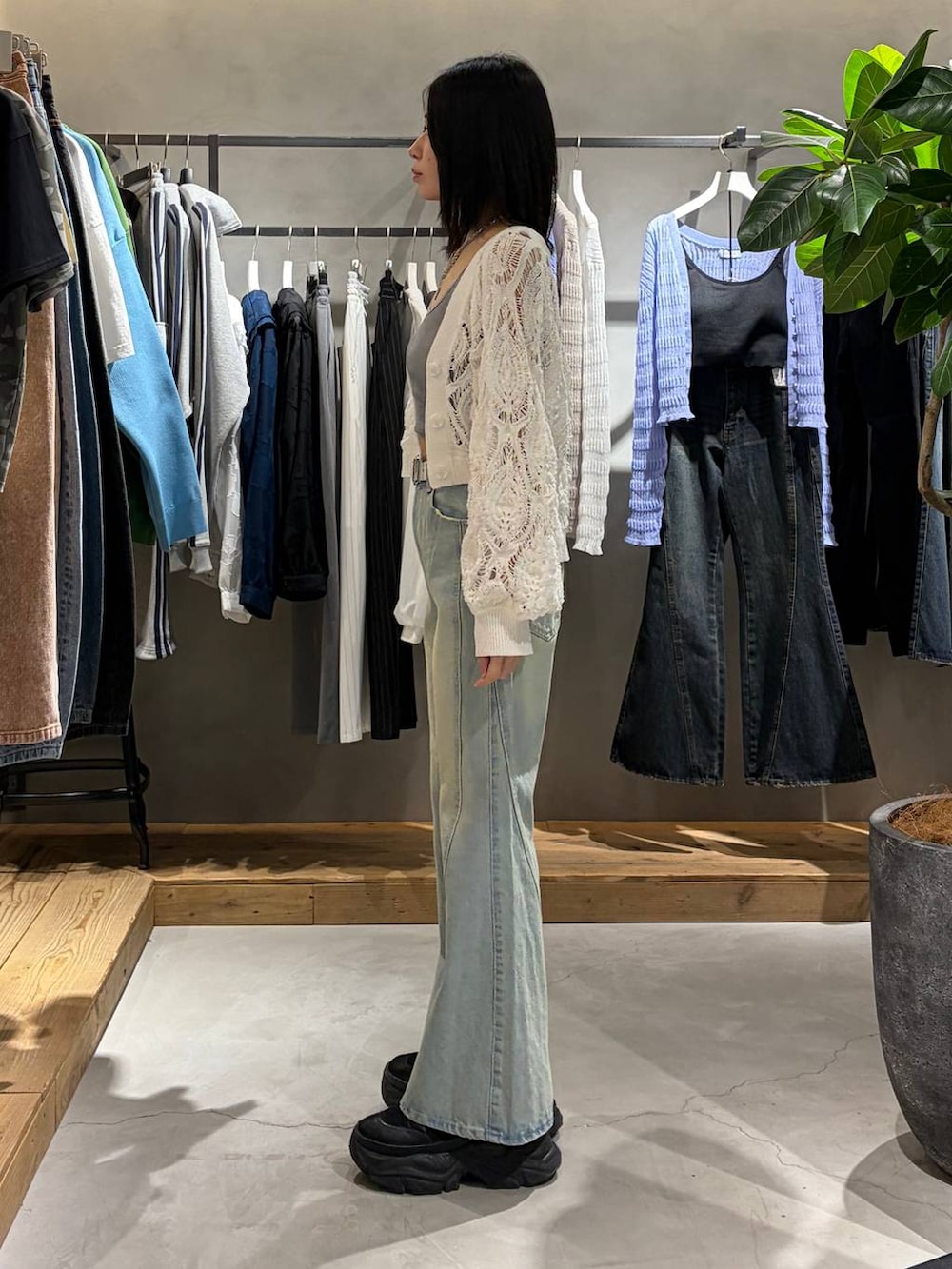 ブラック系のブーツ、グレー系のキャミソール、ホワイト系のカーディガン/ボレロを着用したレディースの春コーディネートの2枚目の写真