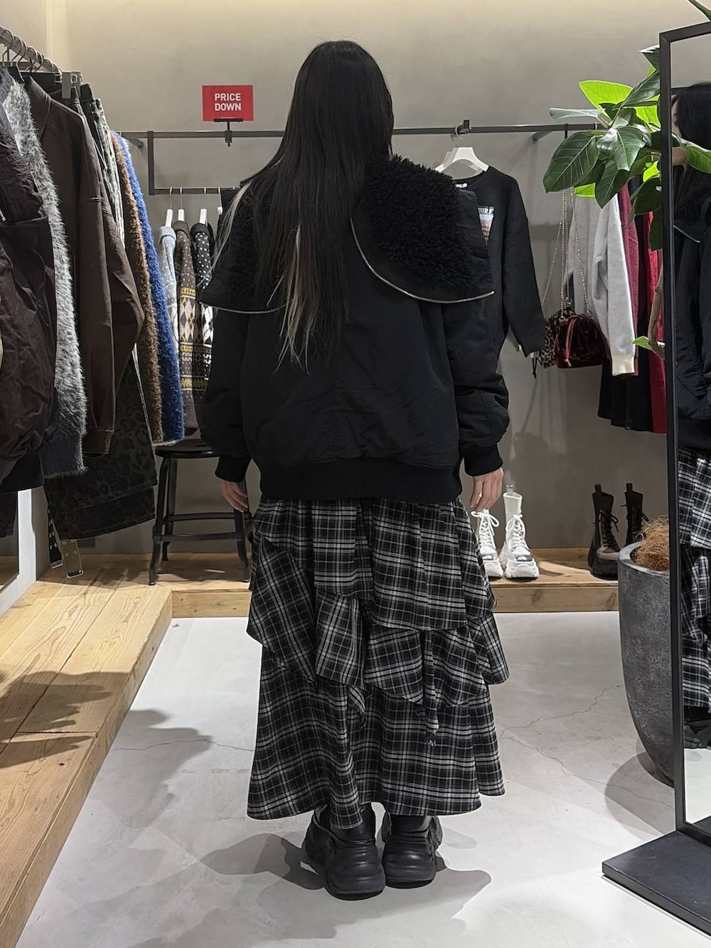 ブラック系のブーツ、ブラック系のブルゾン、レッド系のスウェットを着用したレディースの冬コーディネートの3枚目の写真