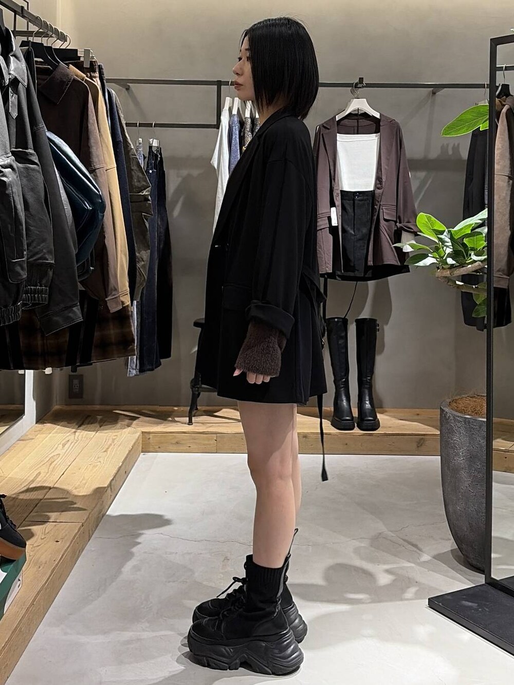 ブラック系のブーツ、ブラック系のテーラードジャケット、ブラウン系のニット/セーターを着用したレディースの秋コーディネートの2枚目の写真