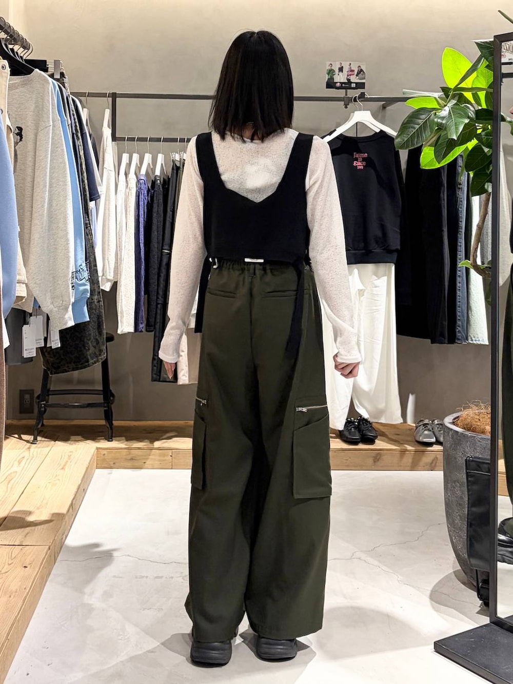 ブラック系のブーツ、グリーン系のスラックス、ホワイト系のTシャツ/カットソーを着用したレディースの春コーディネートの3枚目の写真