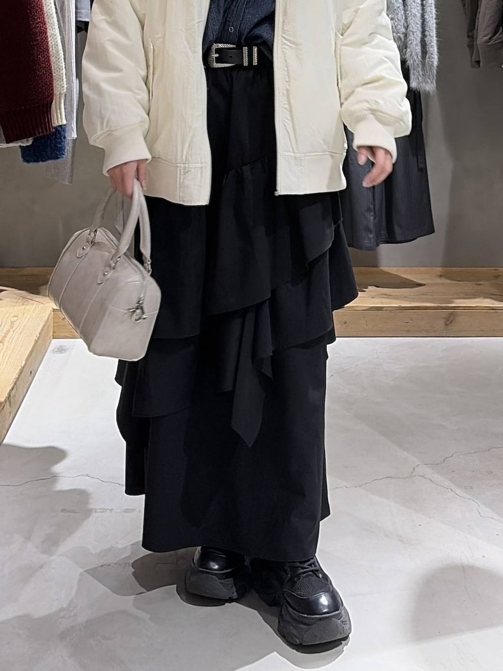 ホワイト系のブルゾン、ホワイト系のTシャツ/カットソー、ブラック系のスカートを着用したレディースの冬コーディネートの5枚目の写真