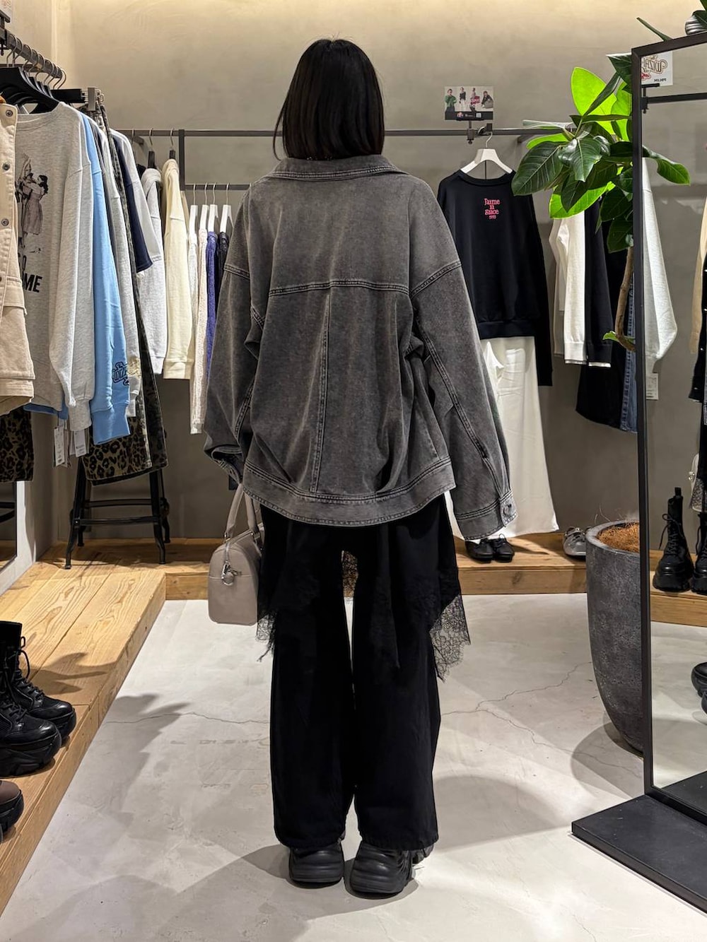 ブラック系のブーツ、ブラック系のデニムパンツ、ホワイト系のボストンバッグを着用したレディースの冬コーディネートの3枚目の写真