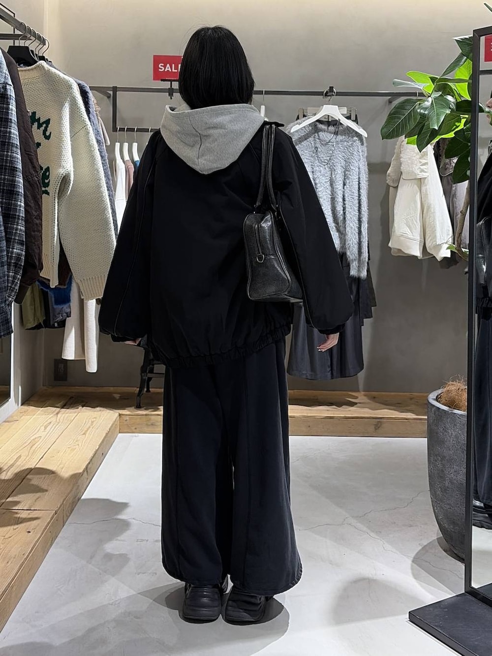 ブラック系のブーツ、ブラック系のニット/セーター、ブラック系のナイロンジャケットを着用したレディースの冬コーディネートの3枚目の写真