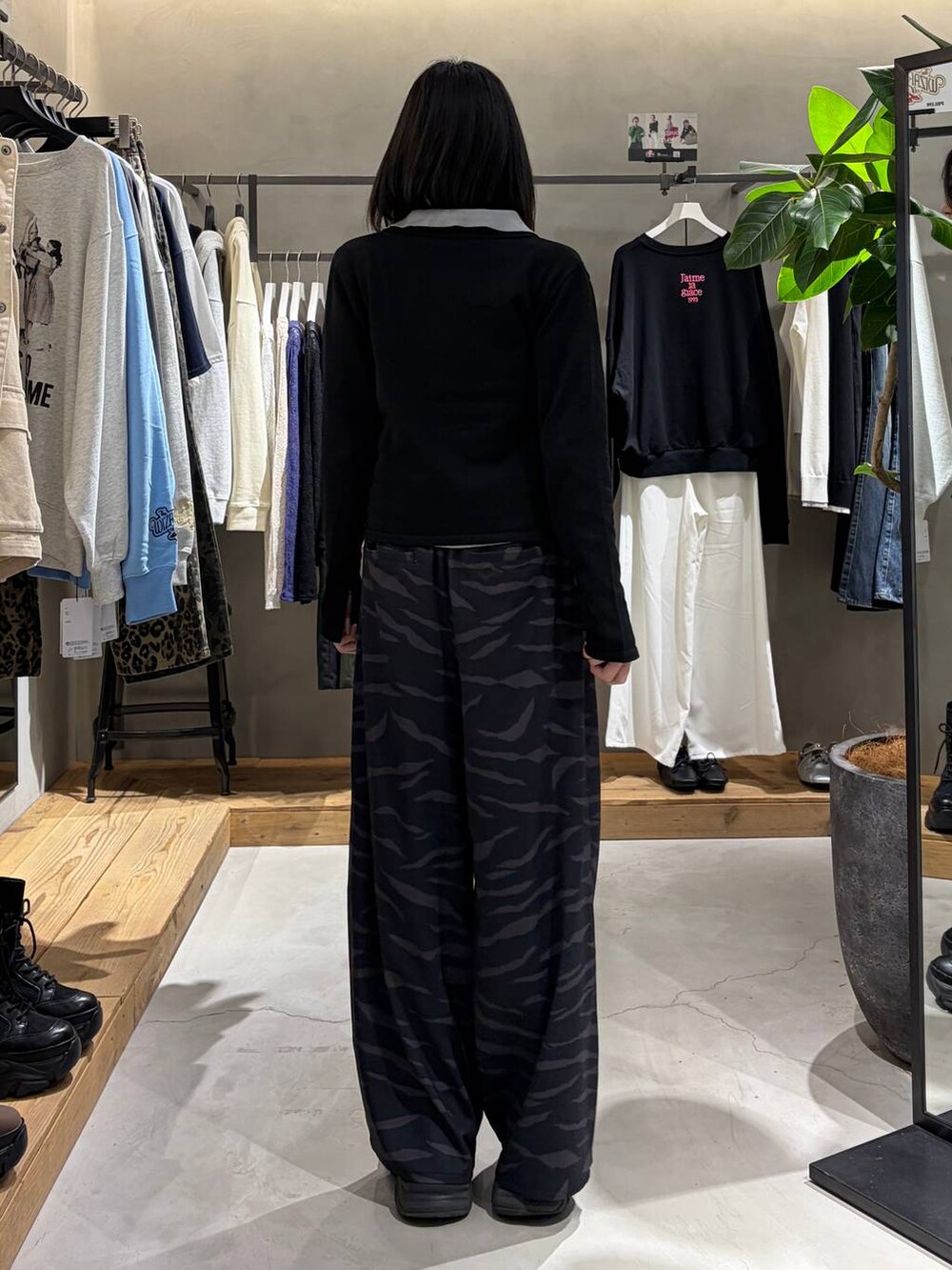 ブラック系のブーツ、その他のスラックス、グレー系のカーディガン/ボレロを着用したレディースの春コーディネートの3枚目の写真