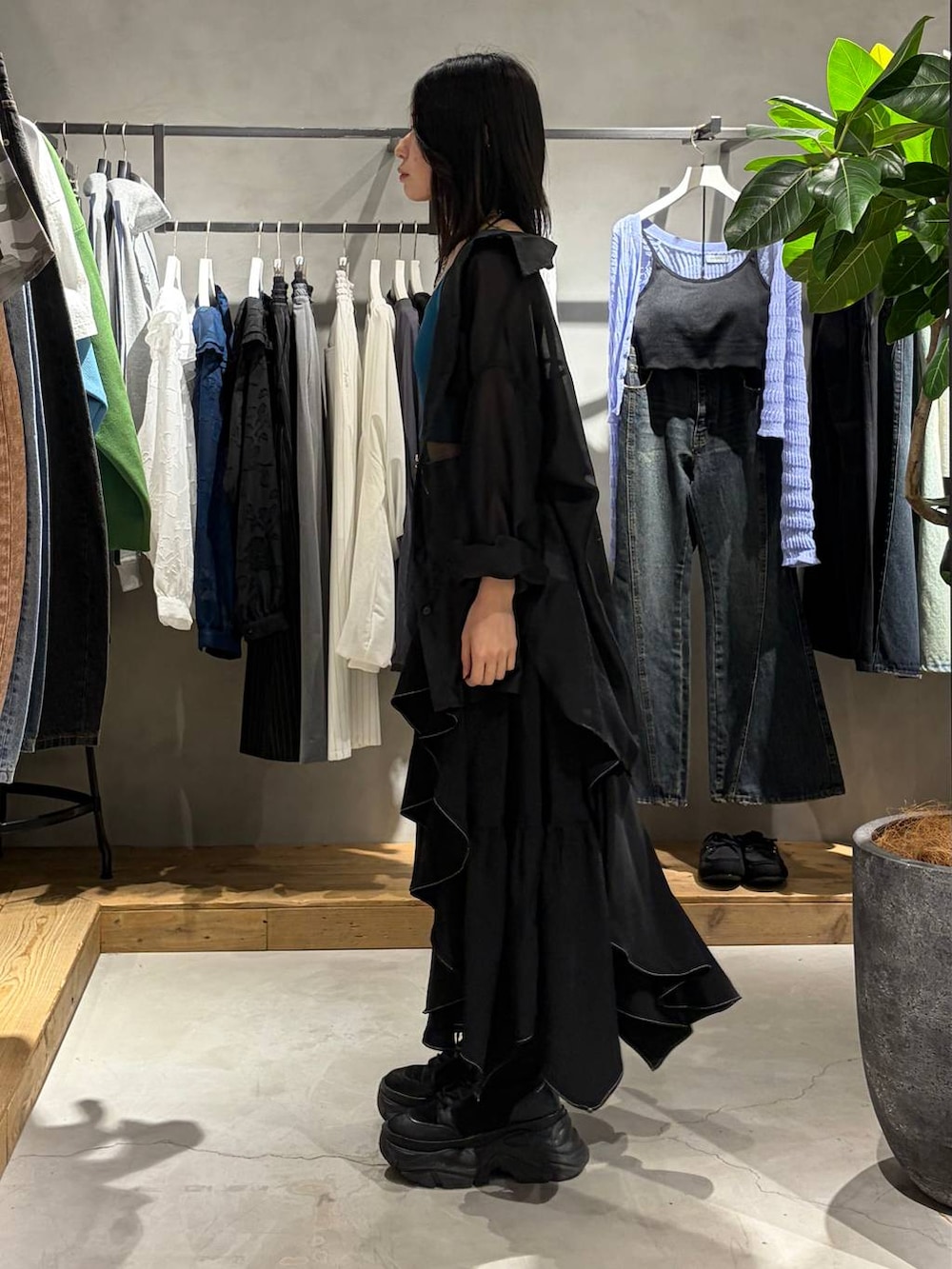 ブラック系のブーツ、グリーン系のキャミソール、ブラック系のスカートを着用したレディースの春コーディネートの2枚目の写真