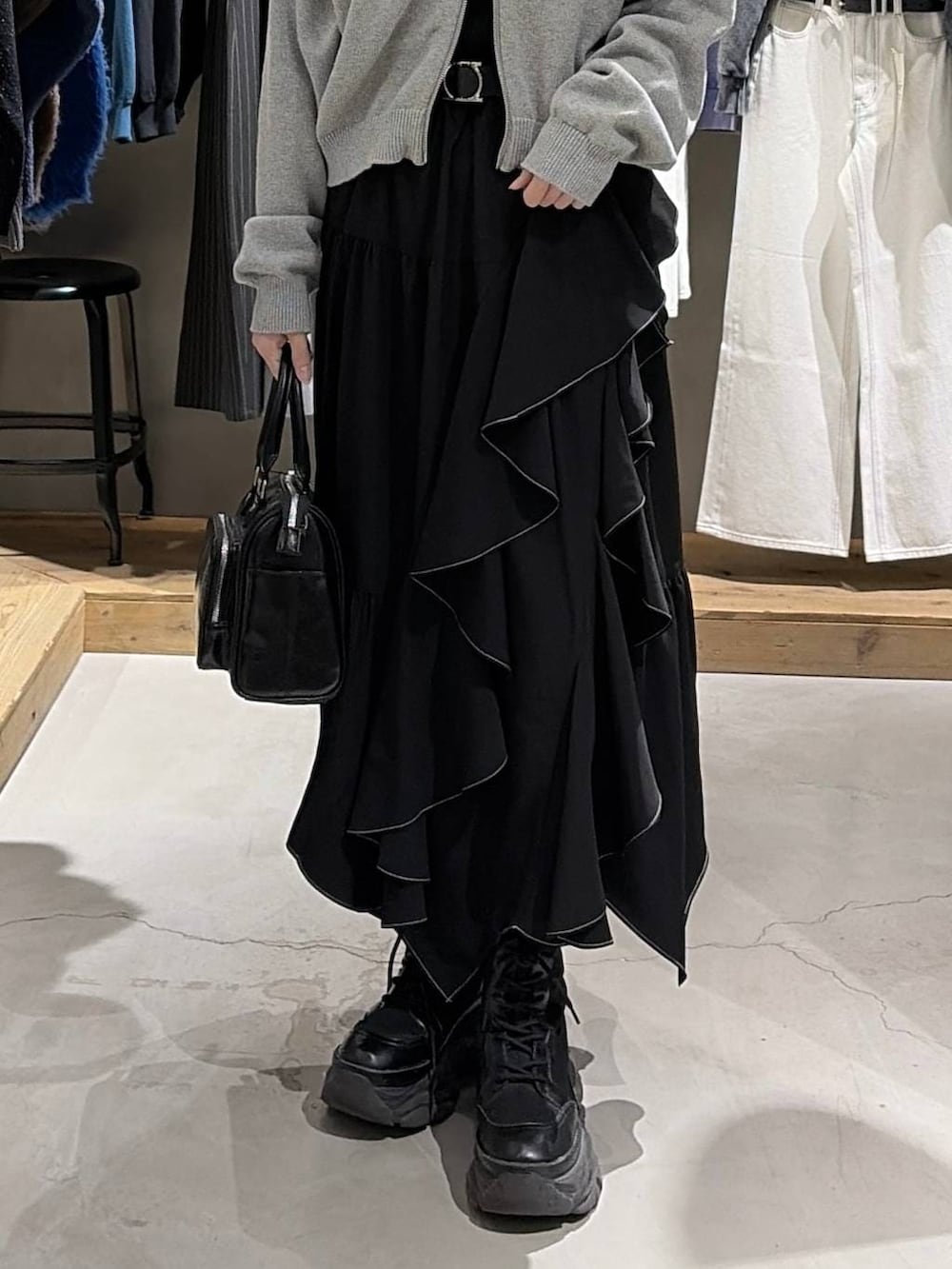 ブラック系のブーツ、ブラック系のスカート、ブラック系のニット/セーターを着用したレディースの冬コーディネートの5枚目の写真