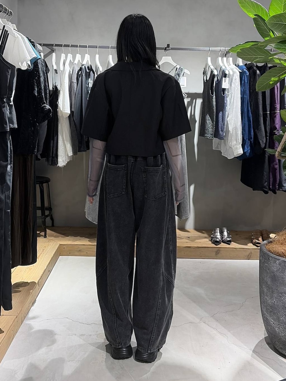 ブラック系のテーラードジャケット、ホワイト系のTシャツ/カットソー、ブラック系のデニムパンツを着用したレディースの夏コーディネートの3枚目の写真