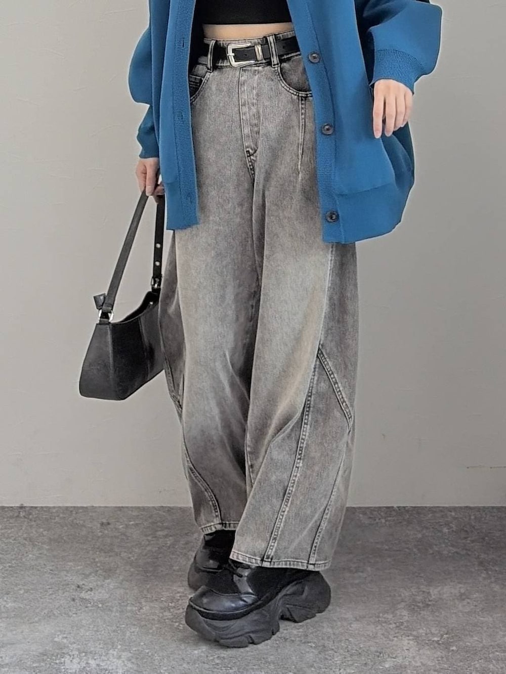 ブラック系のブーツ、ブラック系のハンドバッグ、ブルー系のカーディガン/ボレロを着用したレディースの冬コーディネートの5枚目の写真