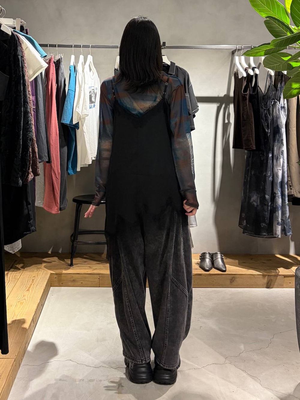 ブラック系のチュニック、ブラック系のスニーカー、ブラック系のデニムパンツを着用したレディースの夏コーディネートの3枚目の写真