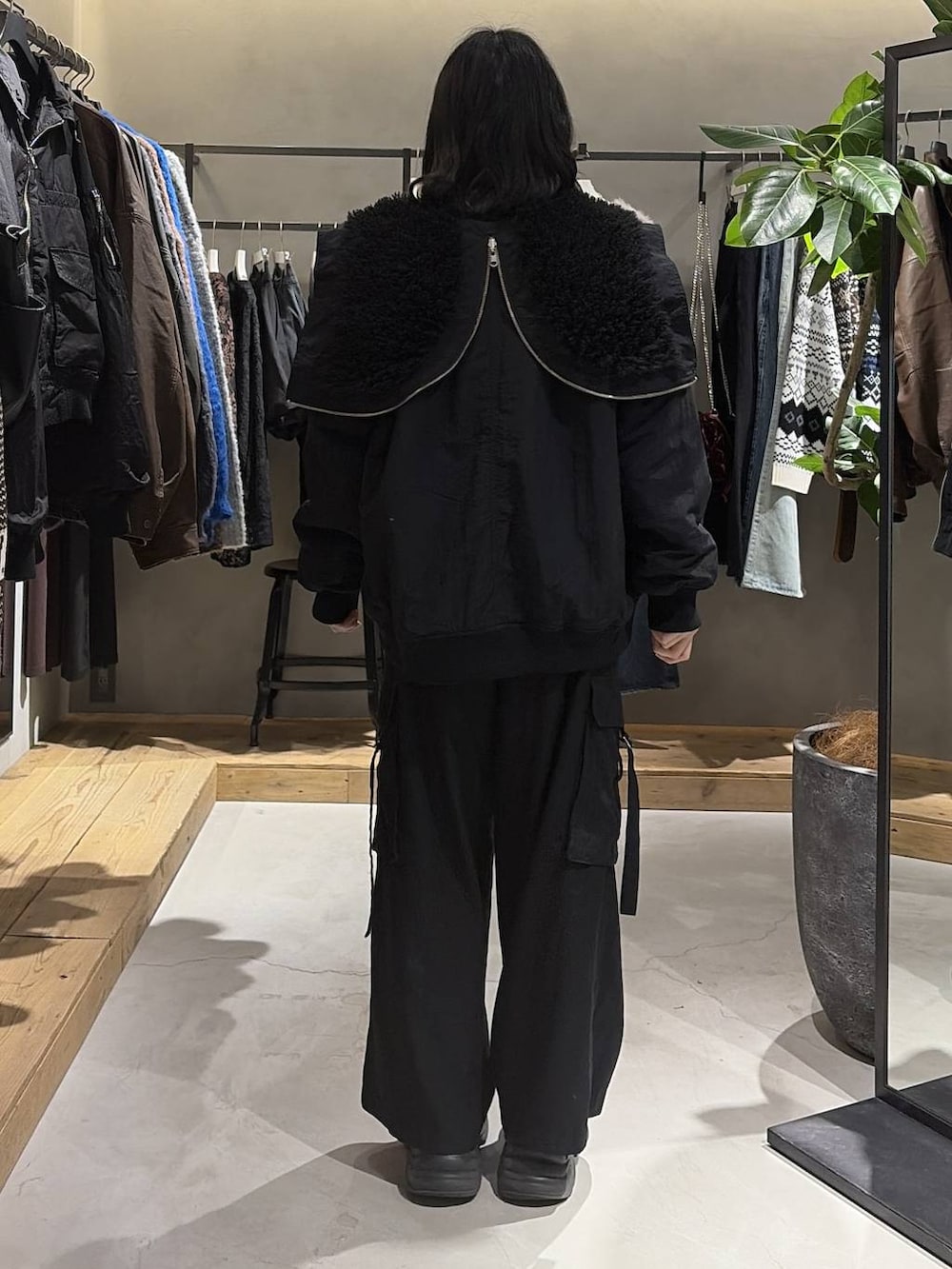 ブラック系のブーツ、ブラック系のブルゾン、ブラック系のスラックスを着用したレディースの冬コーディネートの3枚目の写真