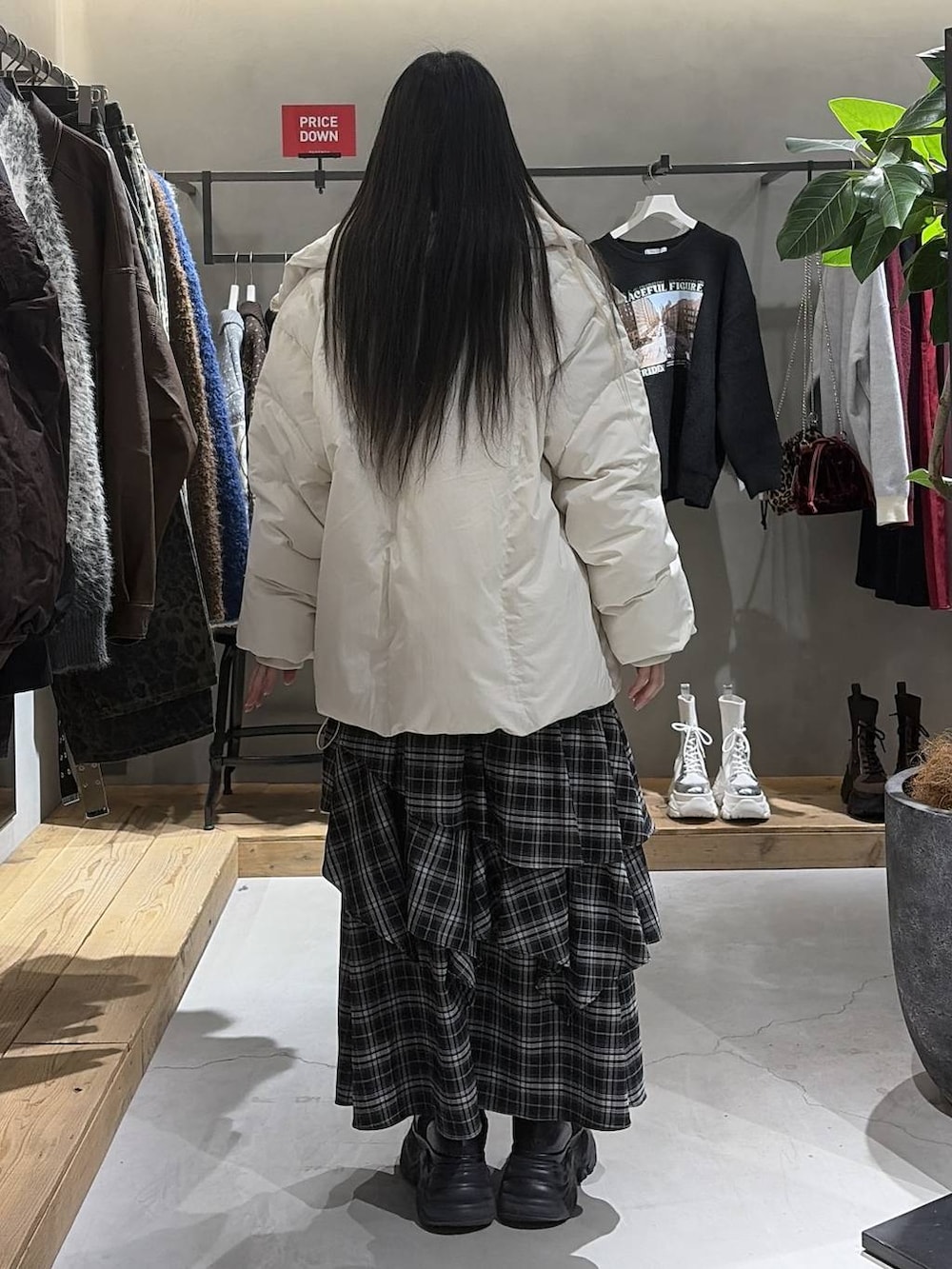 ブラック系のブーツ、ホワイト系のブルゾン、ホワイト系のスカートを着用したレディースの冬コーディネートの3枚目の写真