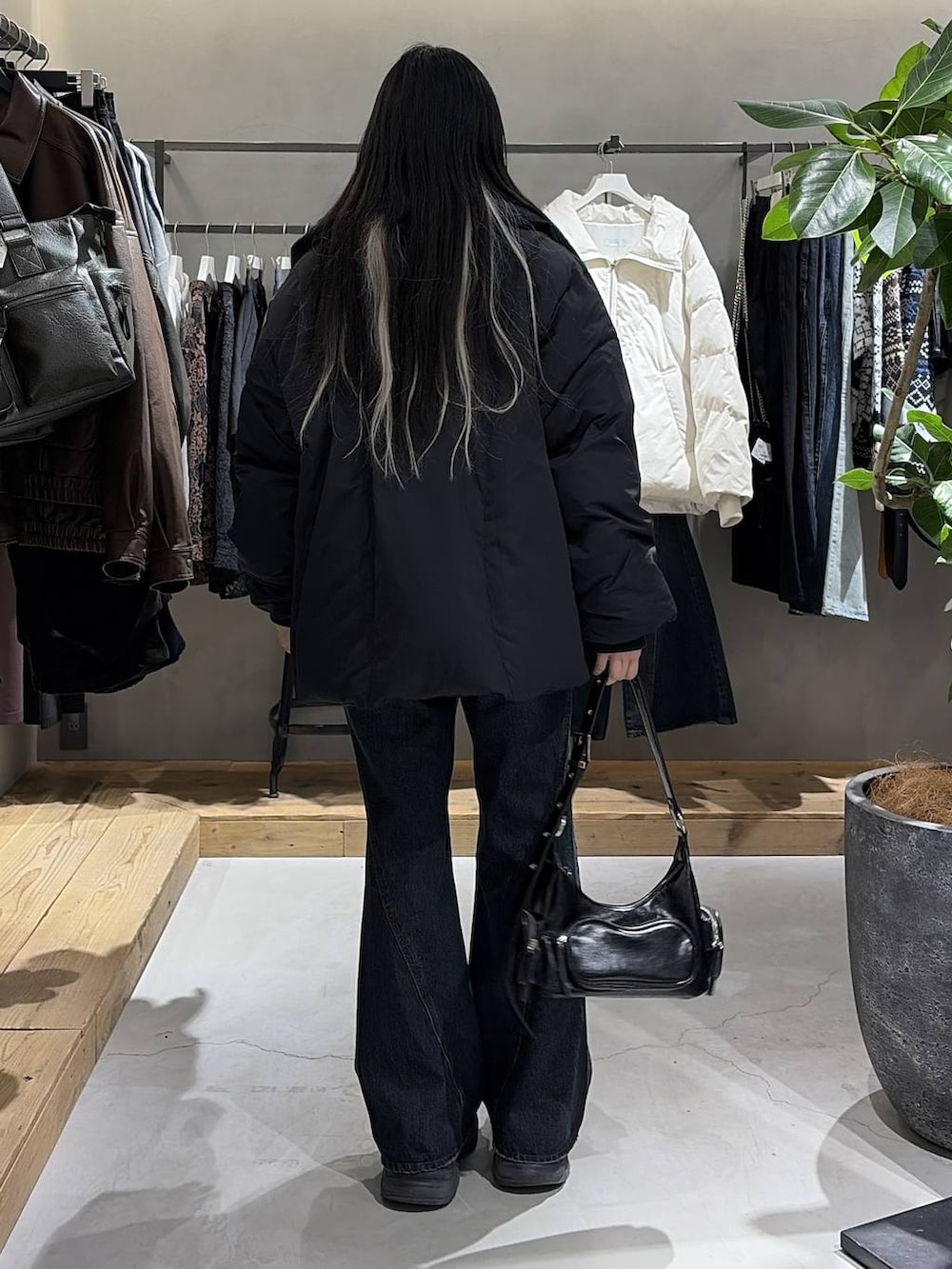 ブラック系のブーツ、ブルー系のデニムパンツ、ブラック系のブルゾンを着用したレディースの冬コーディネートの3枚目の写真