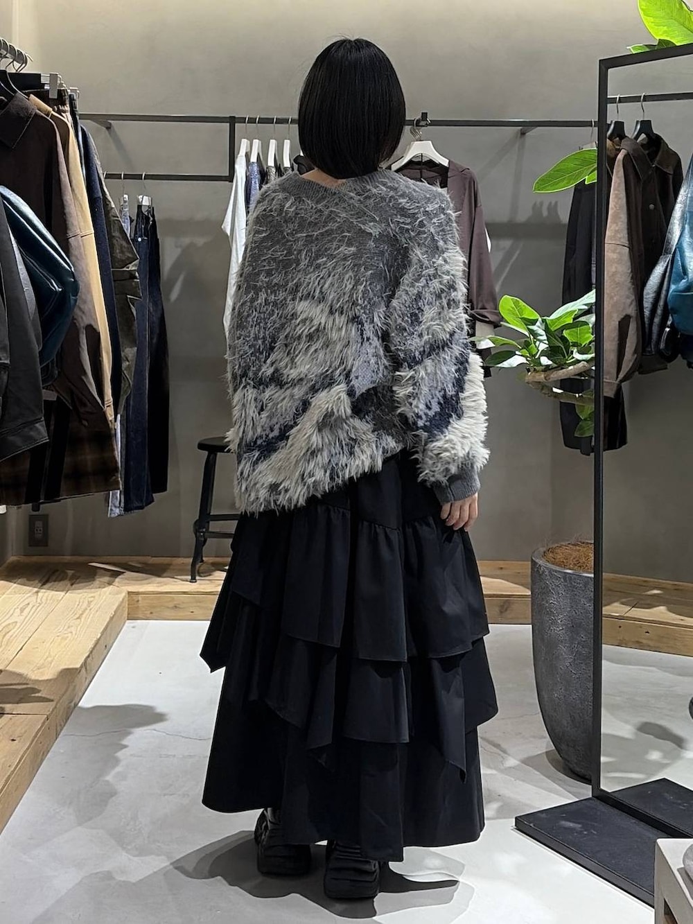 ブラック系のブーツ、ブラック系のキャミソール、ブラック系のスカートを着用したレディースの秋コーディネートの3枚目の写真