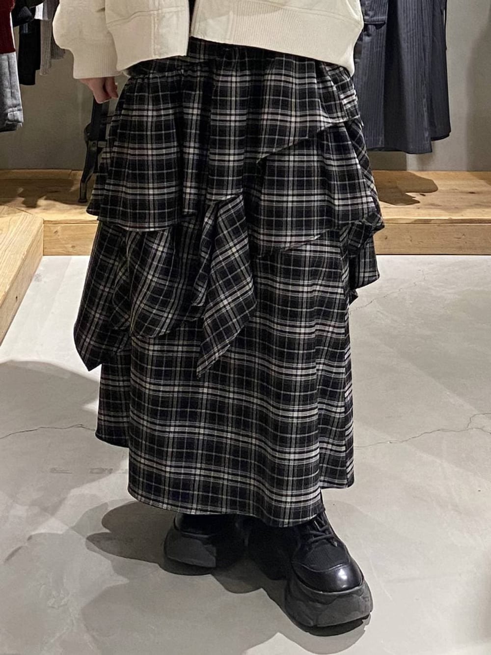 ブラック系のブーツ、ホワイト系のブルゾン、ホワイト系のスカートを着用したレディースの冬コーディネートの5枚目の写真