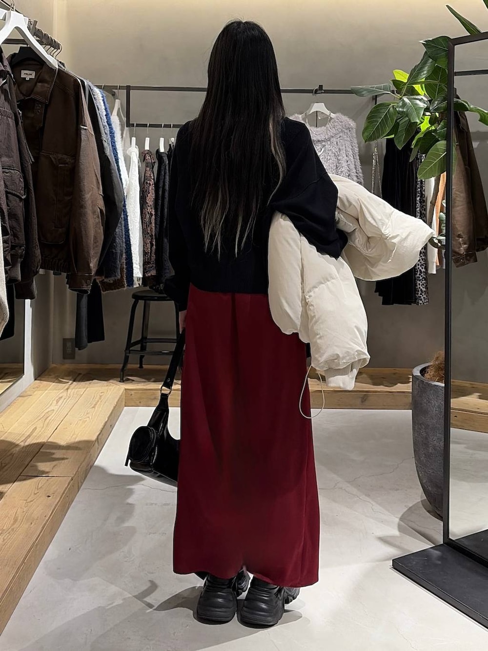 ブラック系のブーツ、ホワイト系のブルゾン、ブラック系のニット/セーターを着用したレディースの冬コーディネートの3枚目の写真