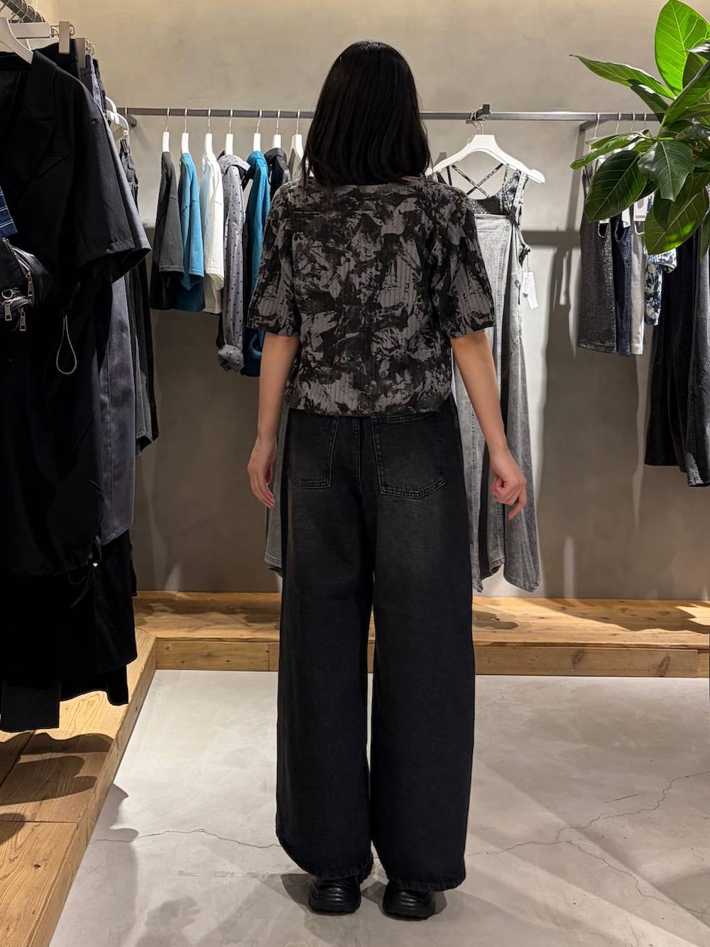 ブラック系のデニムパンツ、ブラック系のキャミソール、ブラック系のサンダルを着用したレディースの夏コーディネートの3枚目の写真