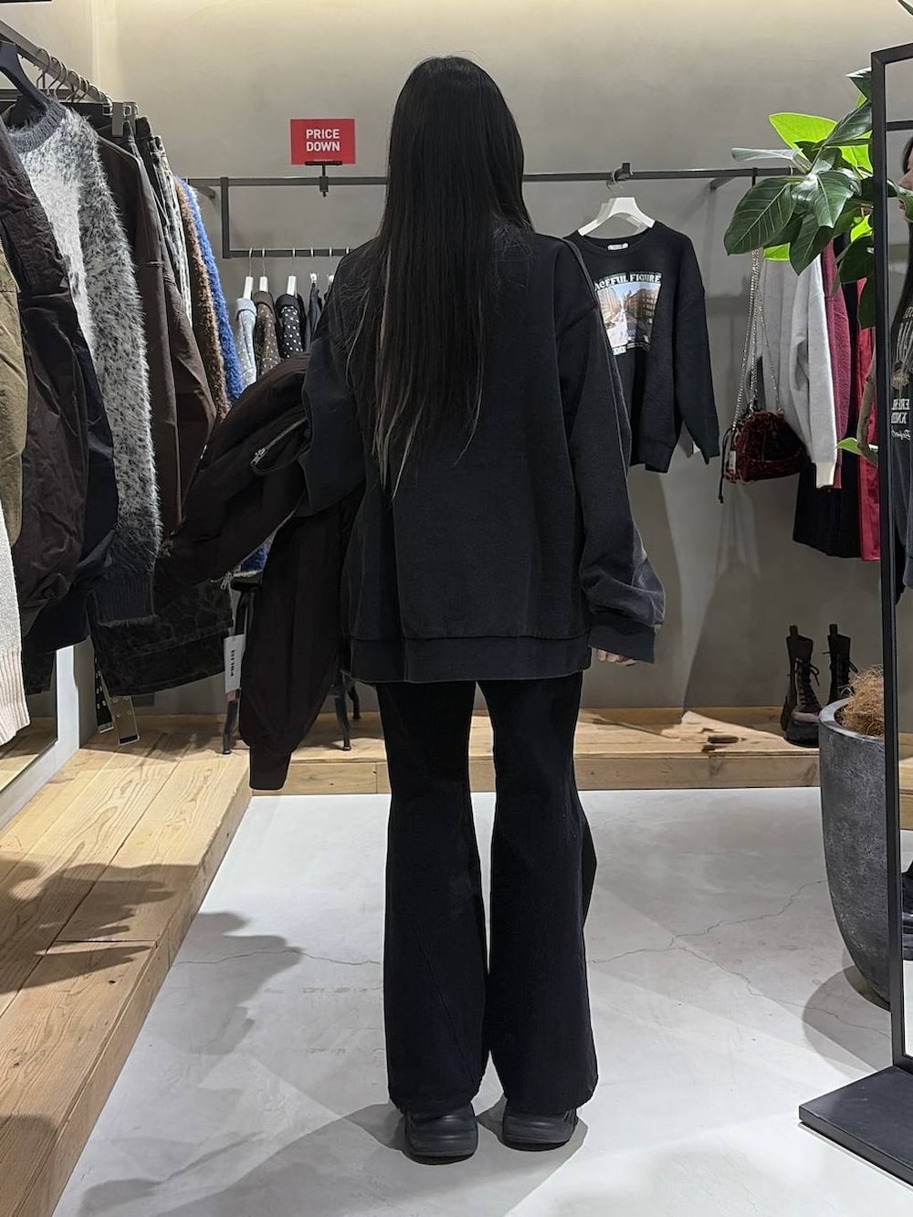 ブラック系のブーツ、ブラック系のデニムパンツ、グレー系のスウェットを着用したレディースの冬コーディネートの3枚目の写真