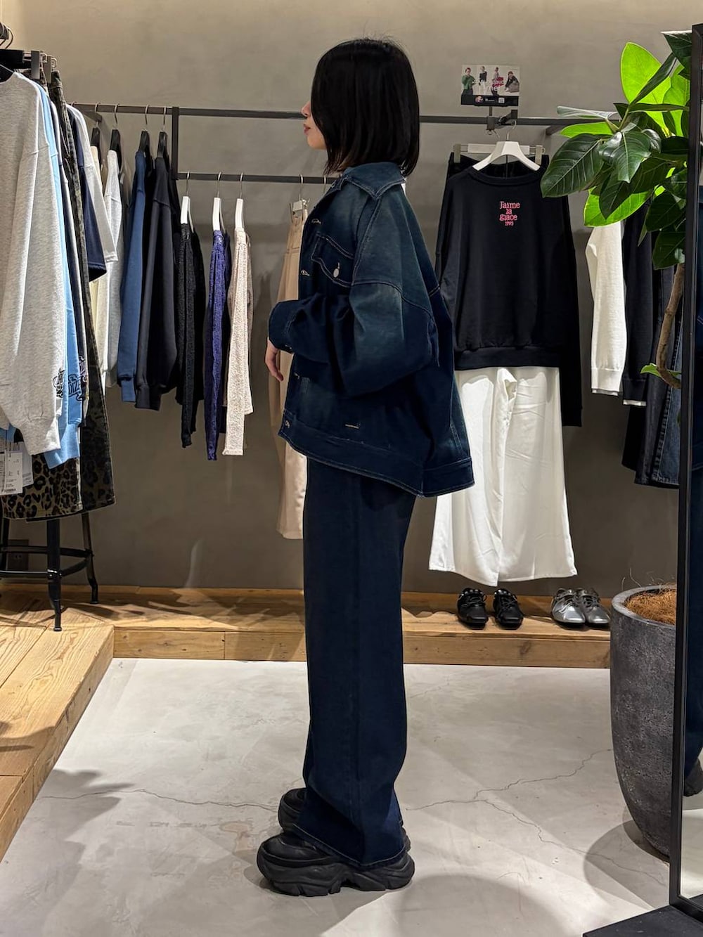 ブラック系のブーツ、ホワイト系のTシャツ/カットソー、ブルー系のスラックスを着用したレディースの春コーディネートの2枚目の写真