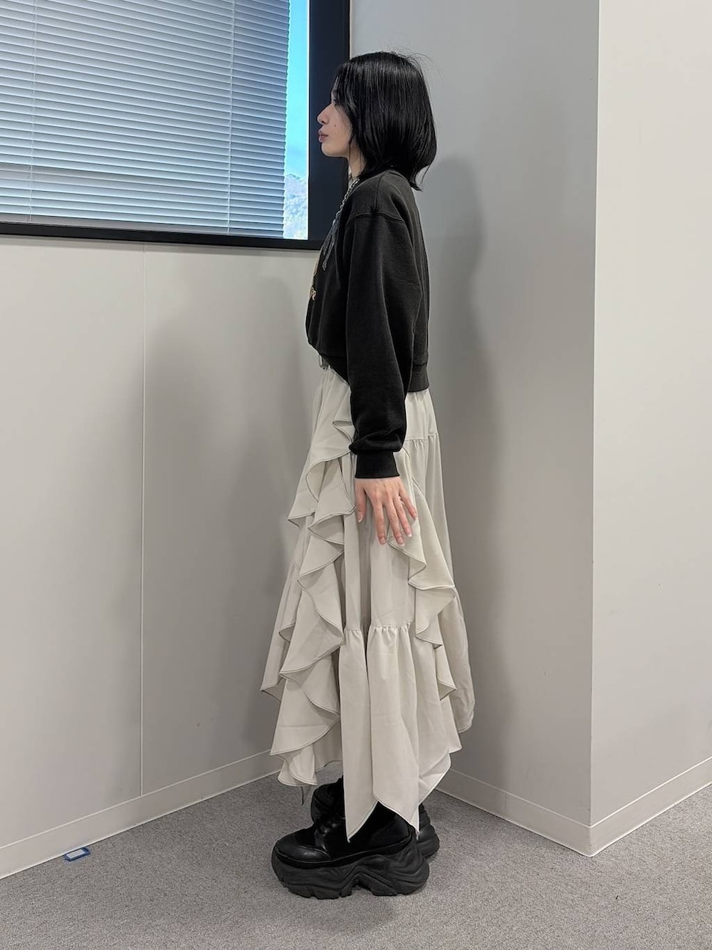 ブラック系のブーツ、ベージュ系のスカート、グレー系のスウェットを着用したレディースの冬コーディネートの2枚目の写真