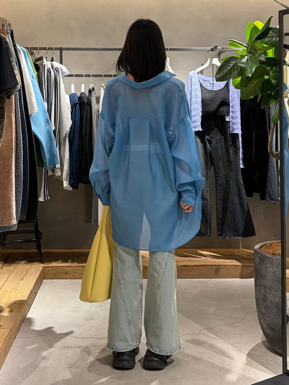 ブラック系のブーツ、グレー系のキャミソール、ブルー系のデニムパンツを着用したレディースの春コーディネートの3枚目の写真