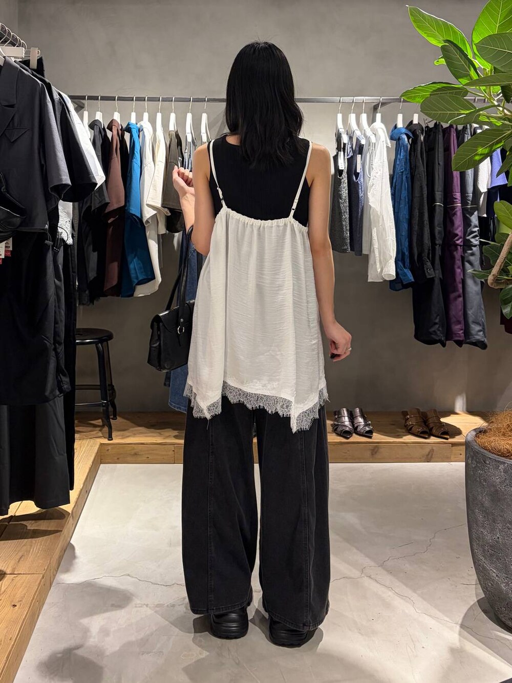 ブラック系のデニムパンツ、ブラック系のスニーカー、ブラック系のタンクトップを着用したレディースの夏コーディネートの3枚目の写真