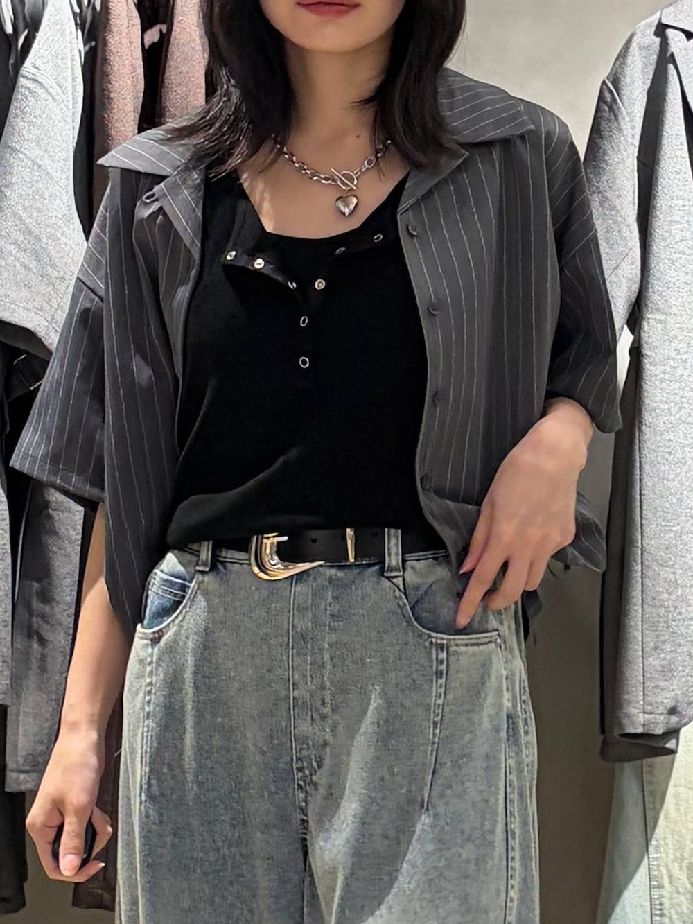 ブルー系のデニムパンツ、ブラック系のサンダル、ブラック系のタンクトップを着用したレディースの夏コーディネートの4枚目の写真