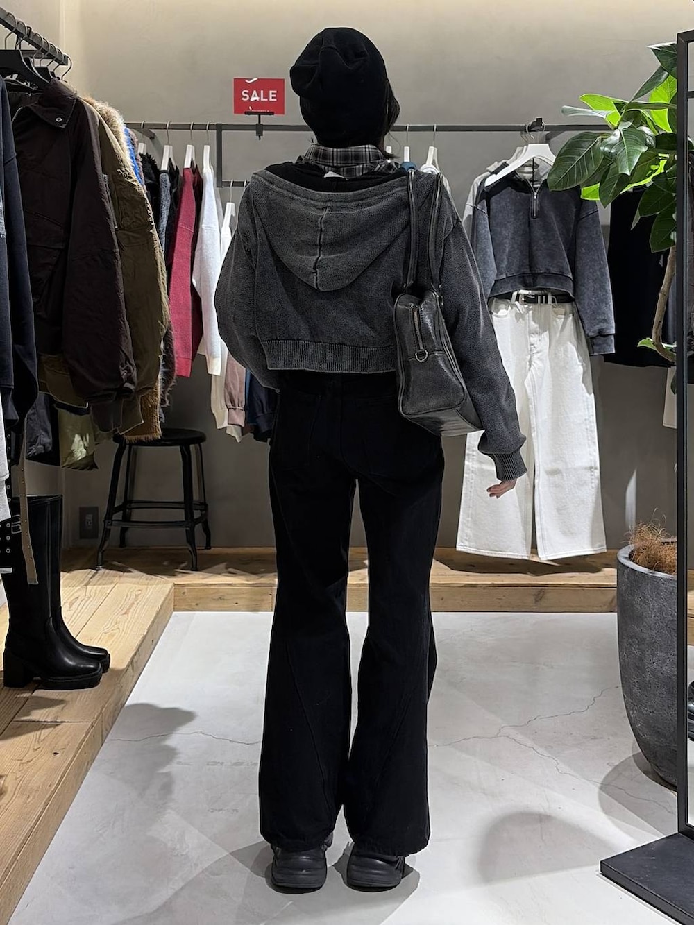 ブラック系のブーツ、ブラック系のボストンバッグ、ブラック系のデニムパンツを着用したレディースの冬コーディネートの3枚目の写真