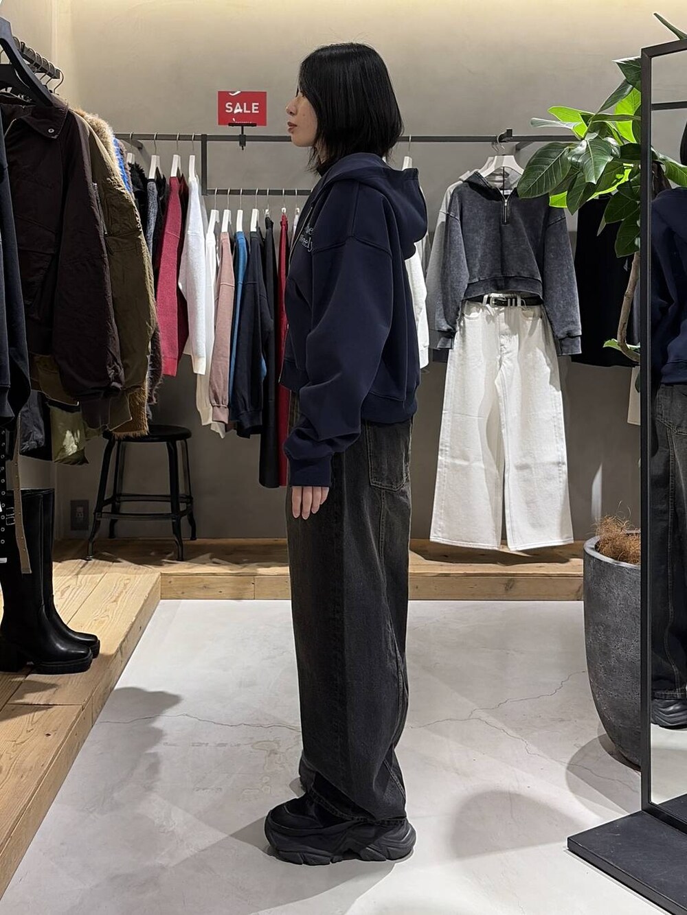 ブラック系のブーツ、ブラック系のニット/セーター、ブラック系のデニムパンツを着用したレディースの冬コーディネートの2枚目の写真