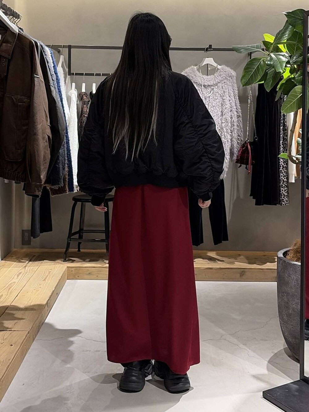 ブラック系のブーツ、ブラック系のブルゾン、レッド系のスカートを着用したレディースの冬コーディネートの3枚目の写真