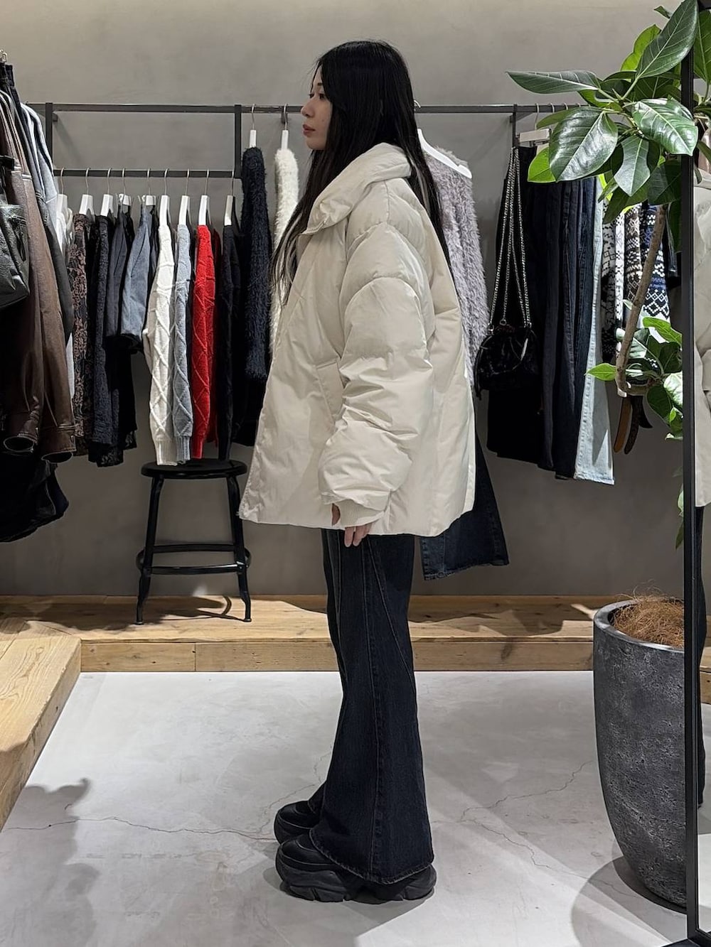 ブラック系のブーツ、ブルー系のデニムパンツ、ホワイト系のブルゾンを着用したレディースの冬コーディネートの2枚目の写真