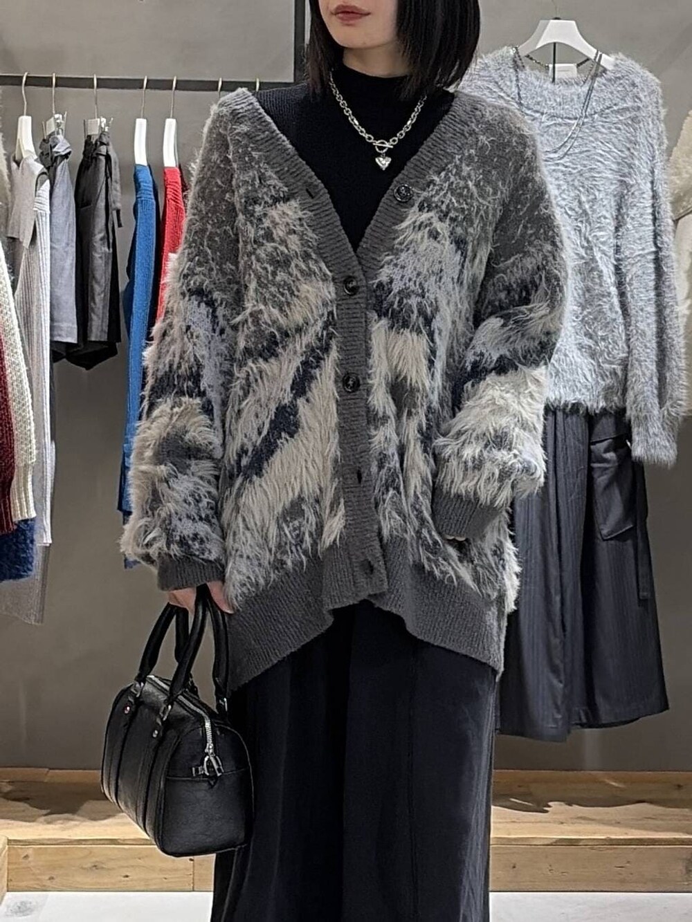 グレー系のカーディガン/ボレロ、ブラック系のニット/セーター、ブラック系のボストンバッグを着用したレディースの冬コーディネートの4枚目の写真