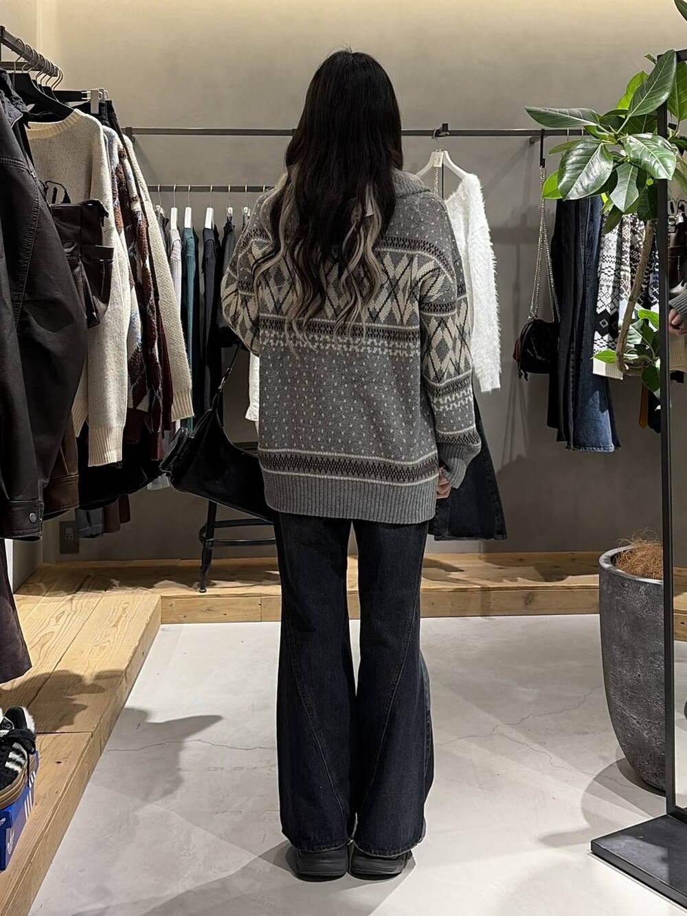 ブラック系のブーツ、ブルー系のデニムパンツ、ブラック系のショルダーバッグを着用したレディースの冬コーディネートの3枚目の写真