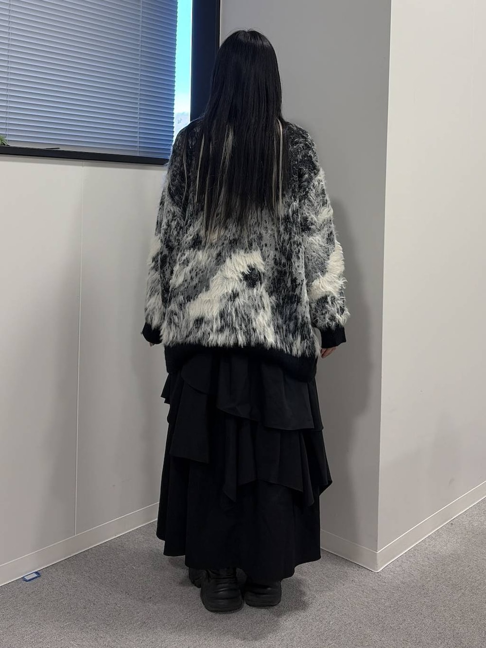 ブラック系のブーツ、ブラック系のスカート、ブラック系のカーディガン/ボレロを着用したレディースの冬コーディネートの3枚目の写真