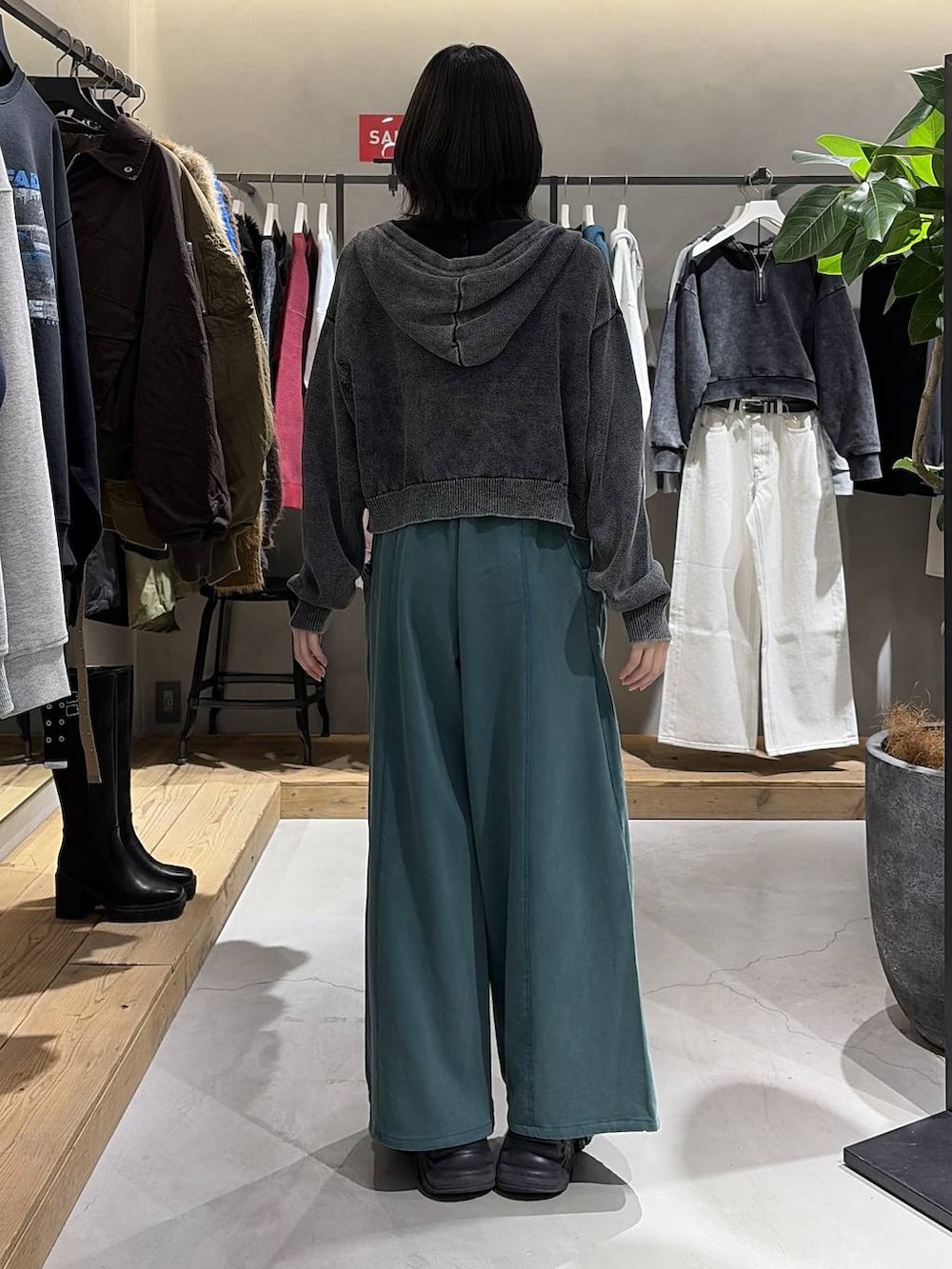 ブラック系のブーツ、ブラック系のニット/セーター、グレー系のパーカーを着用したレディースの冬コーディネートの3枚目の写真