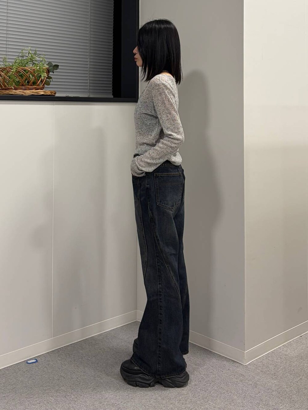 ブラック系のブーツ、ブルー系のデニムパンツ、グレー系のTシャツ/カットソーを着用したレディースの春コーディネートの2枚目の写真