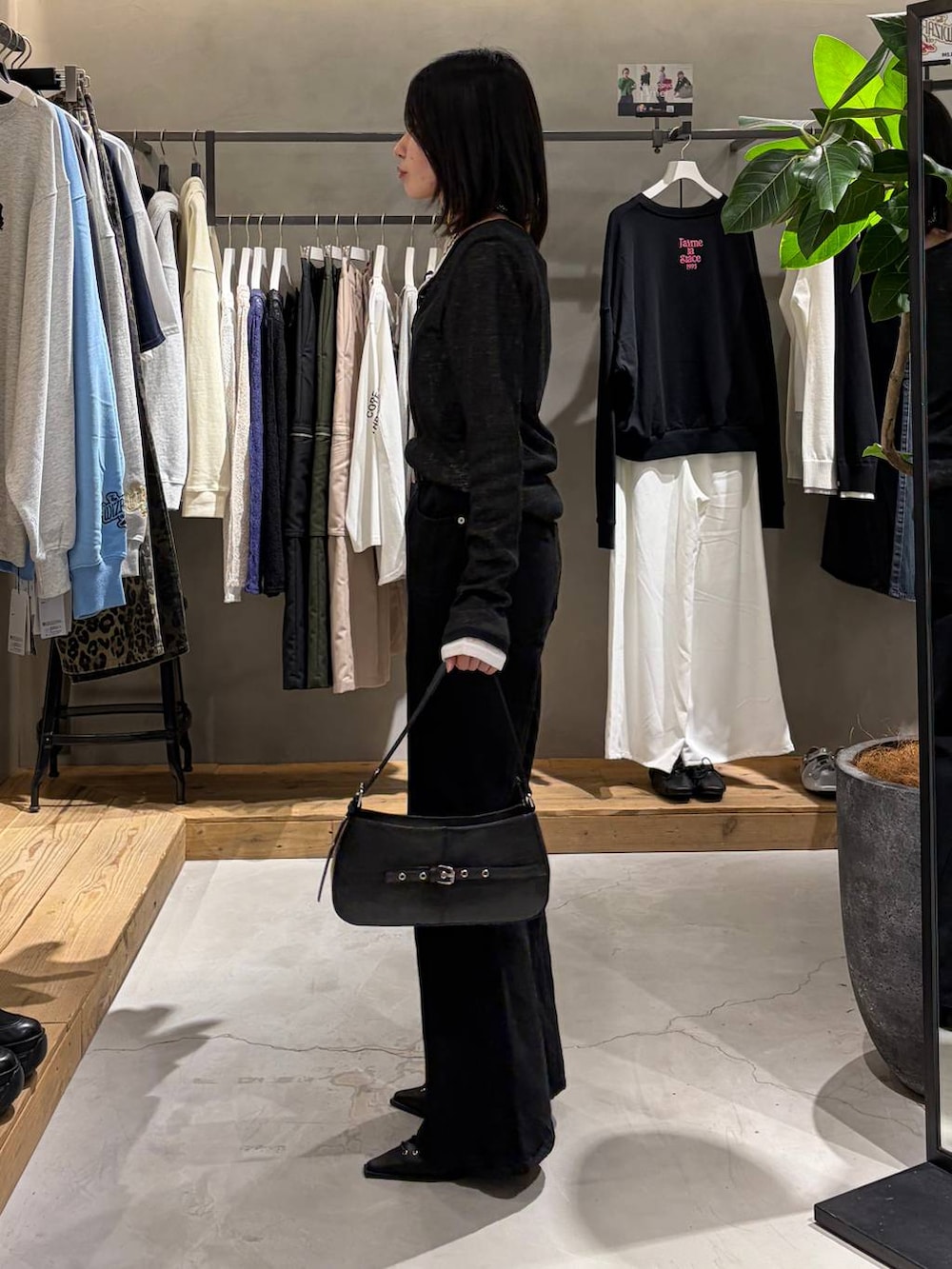 ブラック系のデニムパンツ、ブラック系のハンドバッグ、ブラック系のサンダルを着用したレディースの冬コーディネートの2枚目の写真