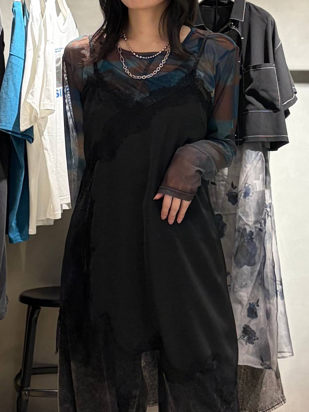 ブラック系のチュニック、ブラック系のスニーカー、ブラック系のデニムパンツを着用したレディースの夏コーディネートの4枚目の写真